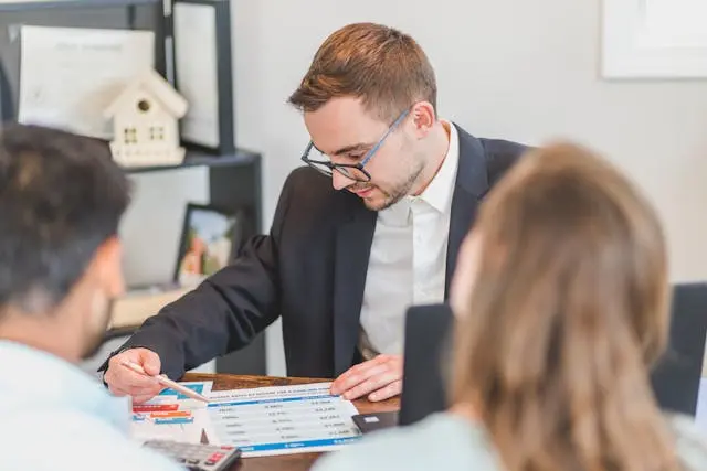 dos personas con profesional del banco