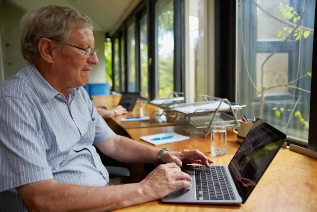 persona mayor frente a una laptop